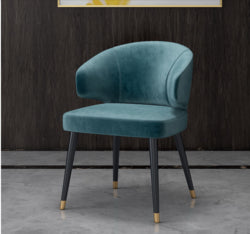 Colorful velvet dining chair with blue seat and black metal legs.