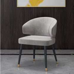 Colorful velvet dining chair with blue seat and black metal legs.